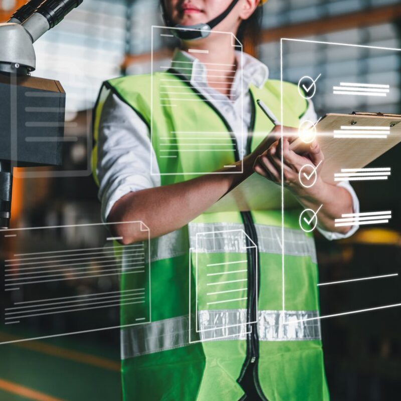 A woman is depicted with a keyboard looking at workflow digital components rendered on an invisible glass screen.